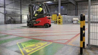 Heinekeni ladu E80 elektritõstuki ja hoiatussümboliga saali põrandal