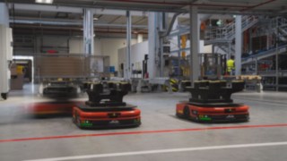 Kolm Linde MH autonoomset mobiilset robotit (AMR) liiguvad laos ringi