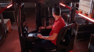 Juht istub Linde Ri16 MH lükandmastiga virnastaja ergonoomilises kabiinis.